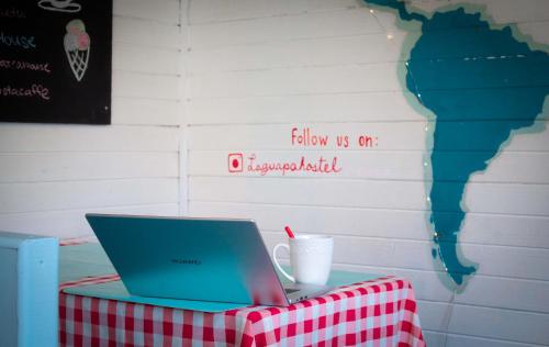 a laptop sitting on a table with a red and white table cloth at La Guapa Hostel in Puerto Varas