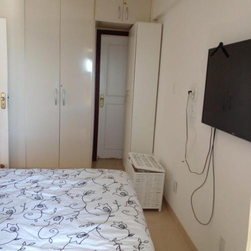 1 dormitorio con 1 cama y TV de pantalla plana en Pequeno Paraiso, en Salvador