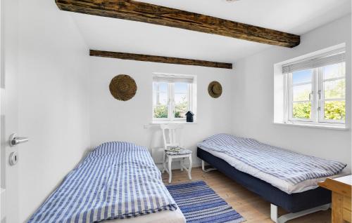 2 Betten in einem Zimmer mit weißen Wänden und Fenstern in der Unterkunft 3 Bedroom Stunning Home In Fllenslev in Føllenslev