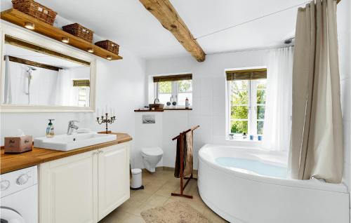 ein weißes Badezimmer mit einer Badewanne und einem Waschbecken in der Unterkunft 3 Bedroom Stunning Home In Fllenslev in Føllenslev