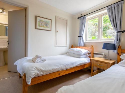 a bedroom with two beds and a window at Estuary House Flat 3 in Salcombe