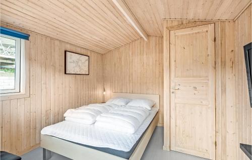 a bed in a room with a wooden wall at 3 Bedroom Lovely Home In Kolding in Kolding