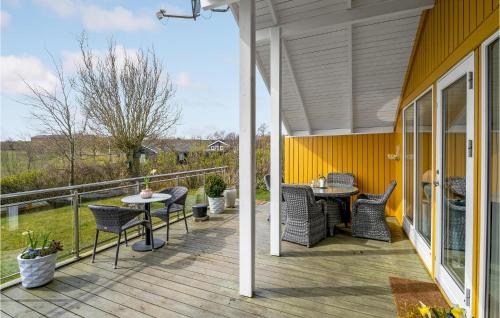 a deck with chairs and tables on a house at Lovely Home In Roslev With Kitchen in Roslev