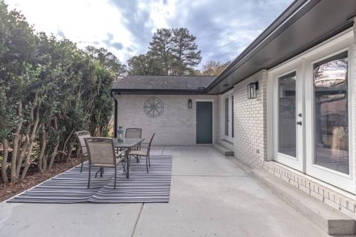 a patio with chairs and a table in front of a house at The Azalea House - modern ranch with king beds in central PTC in Peachtree City