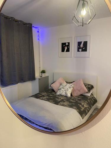 ロンドンにあるCosy 1 Bedroom Apartmentのベッドルーム(円形鏡のベッド付)