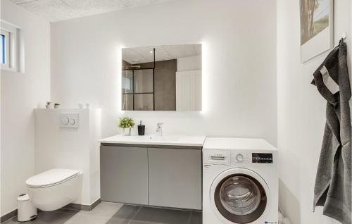 a white bathroom with a washing machine and a sink at Awesome Home In Nibe With Kitchen in Nibe