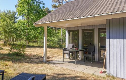 eine abgeschirmte Veranda mit einem Tisch und Stühlen in der Unterkunft Lovely Home In Aakirkeby With Kitchen in Vester Sømarken