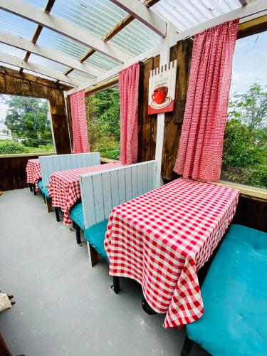 a room with two tables with red and white checkered table cloth at La Guapa Hostel in Puerto Varas