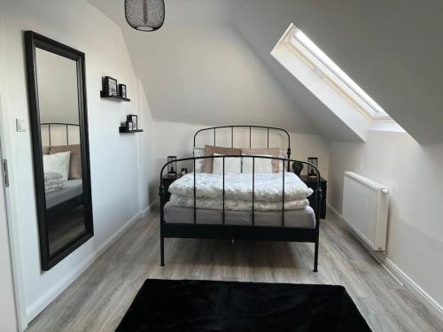 1 dormitorio con cama negra y espejo en 5Minuten von der City entfernte Wohnung mit Parkpl en Bielefeld
