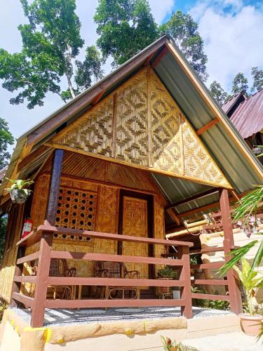 a bamboo house with a thatched roof at Victordelia Hilltop Hostel in San Vicente