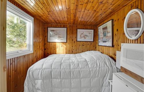 een slaapkamer met een bed in een houten muur bij Beautiful Home In Or With Wifi in Orø
