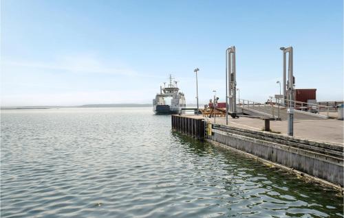 a boat is docked at a dock in the water at Beautiful Home In Orø With Wifi in Orø