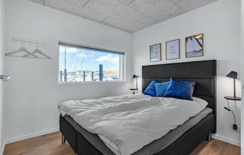 a bedroom with a bed with blue pillows and a window at 2 Bedroom Lovely Ship In Grenaa in Grenå