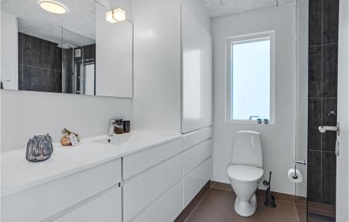 a white bathroom with a toilet and a window at 2 Bedroom Lovely Ship In Grenaa in Grenå