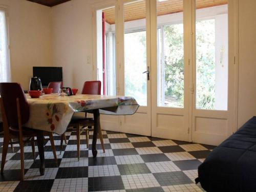 une salle à manger avec une table, des chaises et des fenêtres dans l'établissement Maison 2 pièces à Saint-Pierre-d'Oléron, 4 couchages, proche plage, grand jardin, véranda, calme - FR-1-246A-367, à La Cotinière