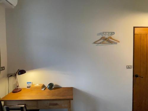 a room with a wooden desk and a lamp on a wall at Cozy House Hostel in Hualien City