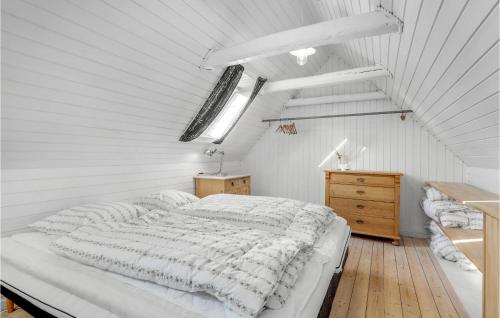 um quarto branco com uma cama grande e uma cómoda em madeira em 2 Bedroom Awesome Home In Rnne em Rønne