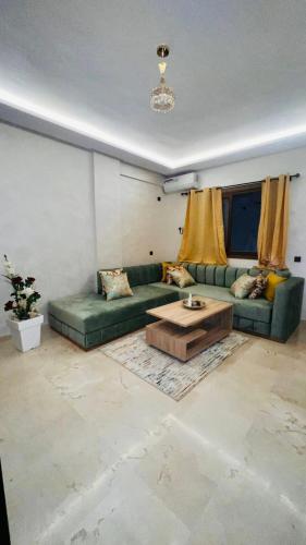 a living room with a green couch and a coffee table at Luxury apartment Gueliz (2 min walk from Train Station) in Marrakech