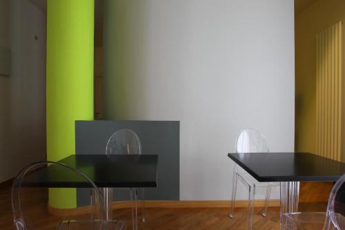 two tables and chairs in front of a green wall at Viasparano B&B in Bari