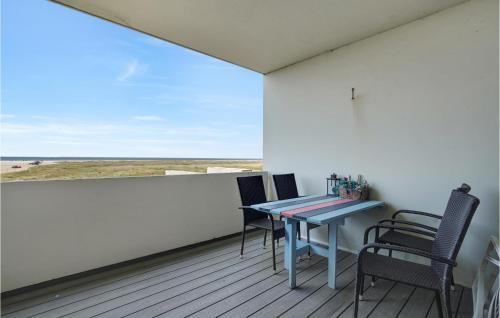 a balcony with a table and chairs and a view of the beach at Beautiful Apartment In Fanø With Sauna in Fanø