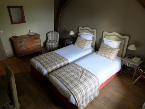 a bedroom with two beds and a dresser at Hostellerie au Coeur du Spinois in Rebecq-Rognon