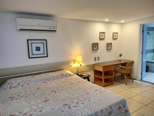 1 dormitorio con cama, escritorio y escritorio en Iate 1211 Luxo Beira Mar Fortaleza, en Fortaleza