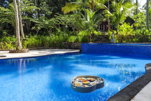 Bila Penida Resort & Farm في نوسا بينيدا: بركة سباحة وفي وسطها وعاء من الطعام