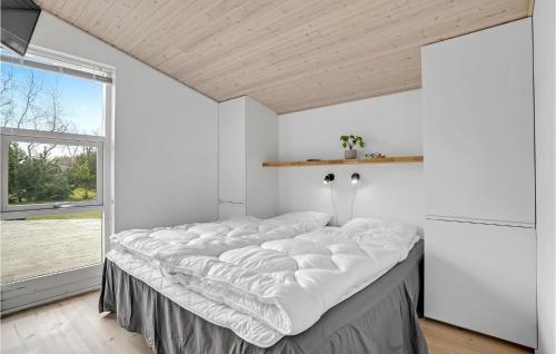 Cette chambre comprend un grand lit et une grande fenêtre. dans l'établissement Lovely Home In Vggerlse With Sauna, à Bøtø By