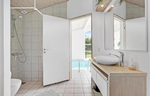 La salle de bains est pourvue d'un lavabo, de toilettes et d'une douche. dans l'établissement Lovely Home In Vggerlse With Sauna, à Bøtø By