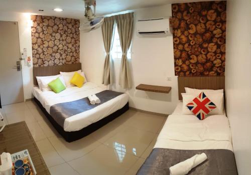 a hotel room with two beds and a window at Garden 96 inn in Kuantan
