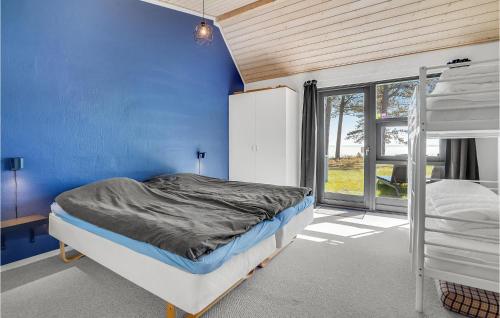 um quarto com uma parede azul e um beliche em 3 Bedroom Awesome Home In Hjslev em Højslev