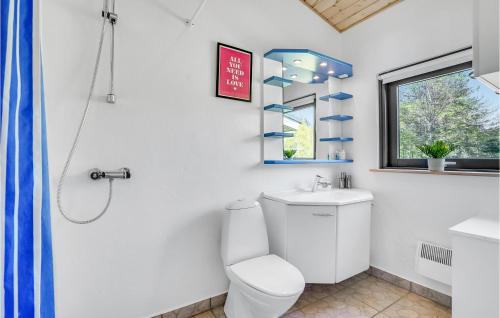 uma casa de banho com um WC, um lavatório e uma janela em 3 Bedroom Awesome Home In Hjslev em Højslev