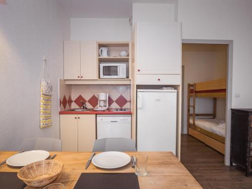 Il comprend une cuisine avec une table et une petite cuisine équipée d'un réfrigérateur. dans l'établissement Studio cosy proche commerces et ski-bus à Chamonix - FR-1-343-239, à Chamonix-Mont-Blanc
