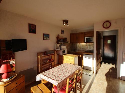 une cuisine avec une table et une petite cuisine avec une table et des chaises dans l'établissement Studio cabine 4 pers, pied des pistes, vue sud - FR-1-297-275, à Auris