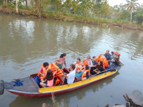 eine Gruppe von Menschen in einem Boot auf einem Fluss in der Unterkunft Brown House Resort in Cần Thơ