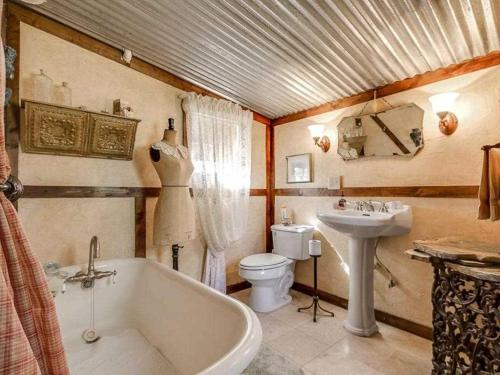 ein Badezimmer mit einer Badewanne, einem WC und einem Waschbecken in der Unterkunft Last Outpost - Sophie's Cottage in Medina