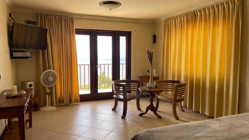 una habitación de hotel con una mesa y sillas y un dormitorio en Lagun Ocean View Villa with Own Private Beach, en Willemstad