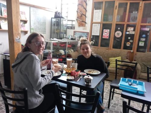 Dos mujeres sentadas en una mesa en un restaurante en Andes Hostel, en Huaraz