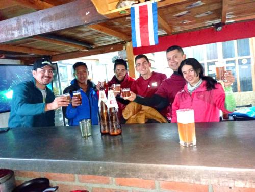 un gruppo di persone sedute al bar a bere birra di Andes Hostel a Huaraz