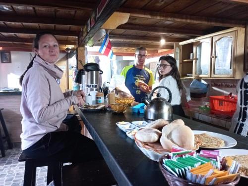 un gruppo di persone sedute a un tavolo con del cibo di Andes Hostel a Huaraz