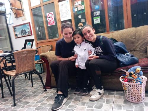 un uomo e una donna seduti su un divano con un bambino di Andes Hostel a Huaraz