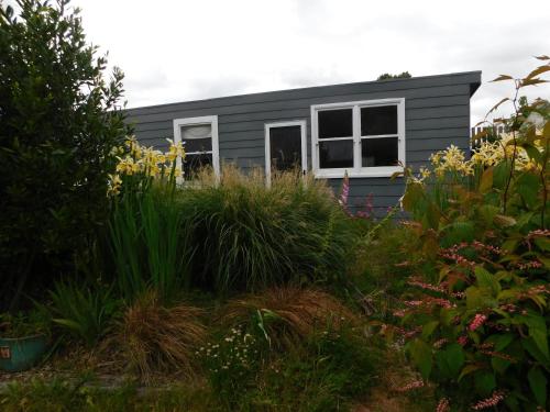 a tiny house in the middle of a garden at The Gardener's Cottage on Warrentinna in Branxholm