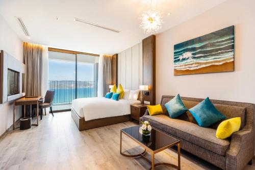 a hotel room with a couch and a bed at PANORAMA Condotel by HLG in Nha Trang