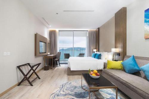 a hotel room with a bed and a couch at PANORAMA Condotel by HLG in Nha Trang