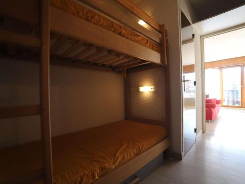 une chambre avec deux lits superposés dans une pièce dans l'établissement Studio cabine 4 pers au pied des pistes avec balcon - Auris en Oisans - FR-1-297-331, à Auris