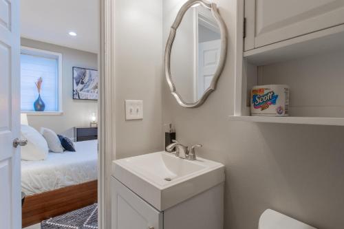 a bathroom with a sink and a mirror and a bed at Baltimore's Home Away From Home apts in Baltimore