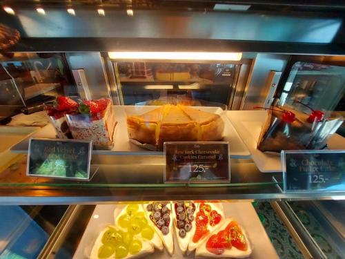 a display case in a bakery with different types of food at Raya Buri Resort Kanchanaburi in Si Sawat