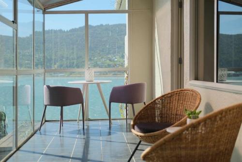 um quarto com uma mesa e cadeiras e uma grande janela em Stairway to heaven em Dunedin