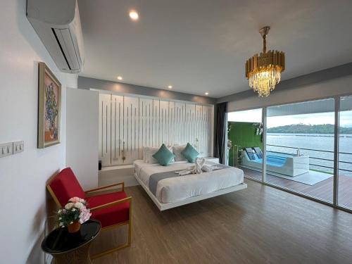 a bedroom with a bed and a view of the water at Raya Buri Resort Kanchanaburi in Si Sawat