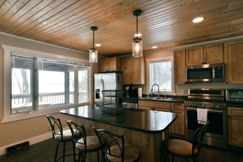 a kitchen with wooden cabinets and a kitchen island with chairs at Spruce Haven home in Hayward